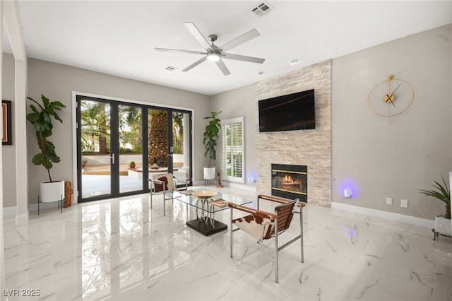 unfurnished living room featuring visible vents, baseboards, a stone fireplace, marble finish floor, and a ceiling fan