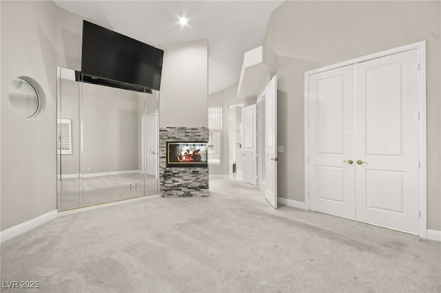 unfurnished living room featuring baseboards, carpet floors, and a tiled fireplace