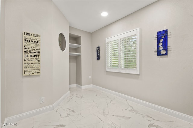 empty room with recessed lighting, marble finish floor, and baseboards