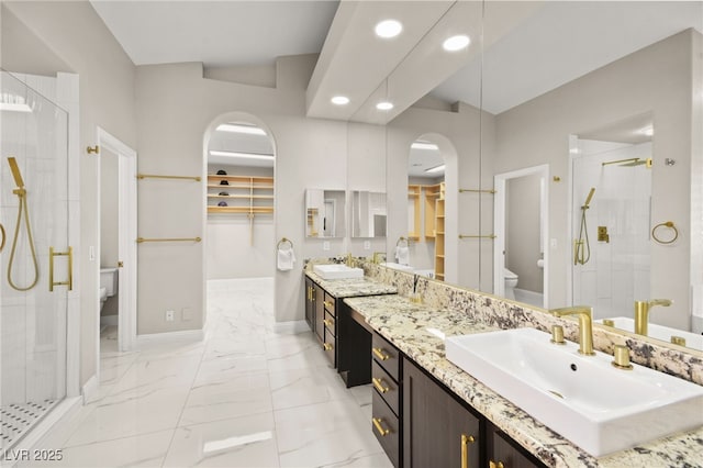 full bathroom featuring vanity, baseboards, a shower stall, toilet, and marble finish floor