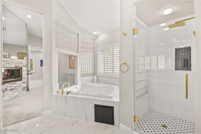 full bath featuring a garden tub, a glass covered fireplace, a shower stall, and vaulted ceiling