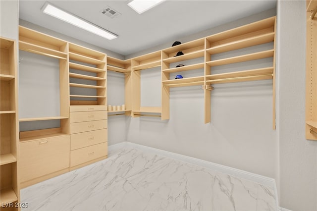 walk in closet with visible vents and marble finish floor