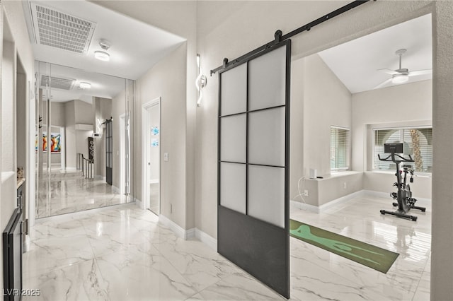 hall featuring visible vents, marble finish floor, baseboards, and a barn door