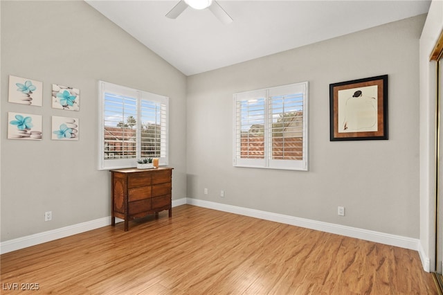 unfurnished room featuring lofted ceiling, light wood-style floors, a wealth of natural light, and ceiling fan