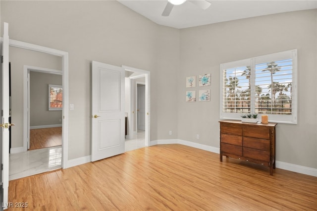 unfurnished bedroom with light wood-style floors, baseboards, and ceiling fan