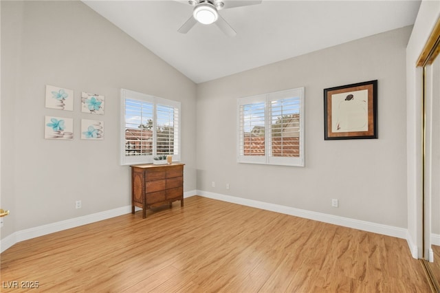 bedroom featuring light wood finished floors, multiple windows, baseboards, and vaulted ceiling