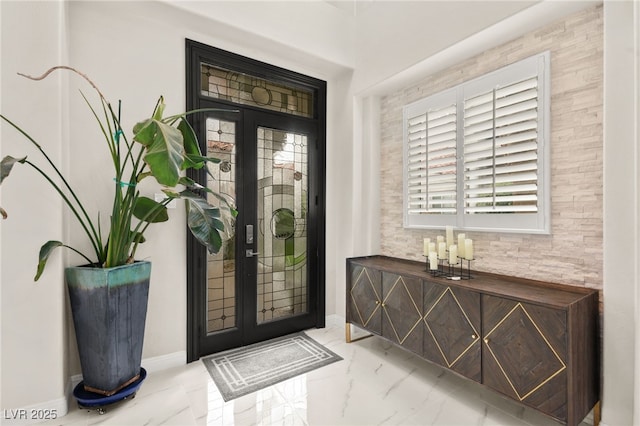 entryway featuring baseboards and marble finish floor