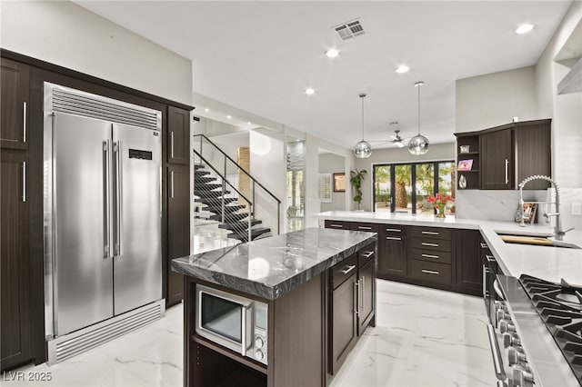 kitchen featuring marble finish floor, a sink, open shelves, stainless steel appliances, and dark brown cabinetry