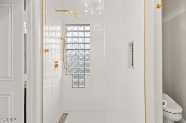 bathroom with toilet and a tile shower