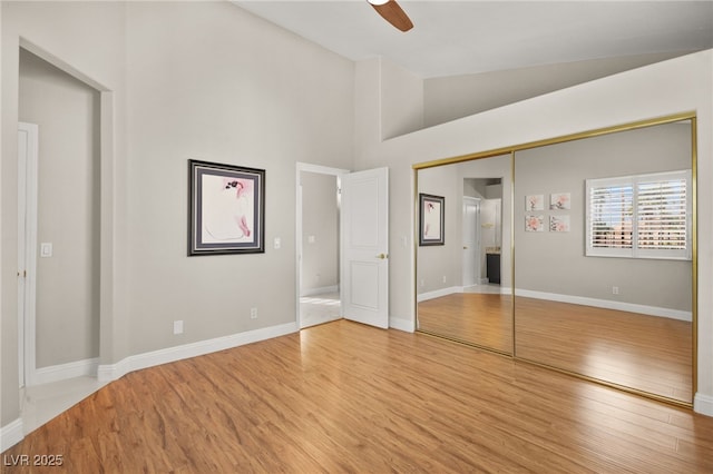 unfurnished bedroom featuring light wood-style floors, baseboards, a closet, and ceiling fan