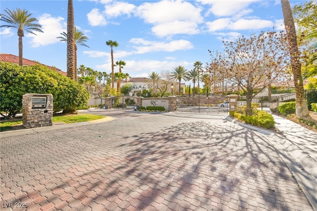 view of road with curbs, a residential view, a gated entry, and a gate