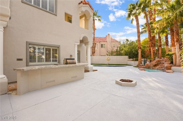 view of patio with fence, a grill, and an outdoor fire pit