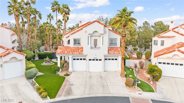 mediterranean / spanish-style home with a tile roof, concrete driveway, an attached garage, and stucco siding