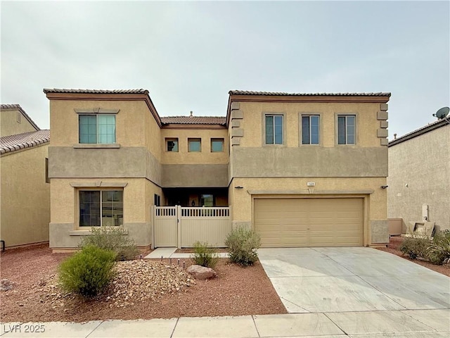 mediterranean / spanish-style home featuring fence, concrete driveway, stucco siding, a garage, and a gate