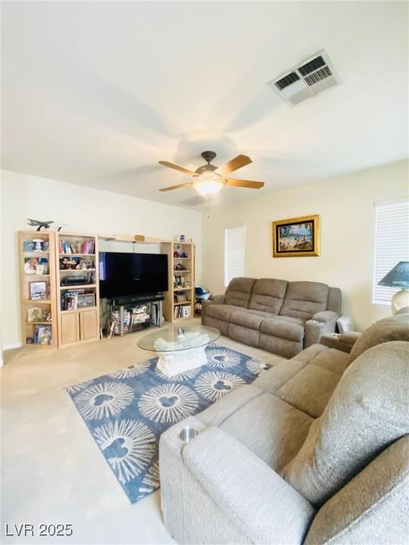 living area featuring visible vents and ceiling fan