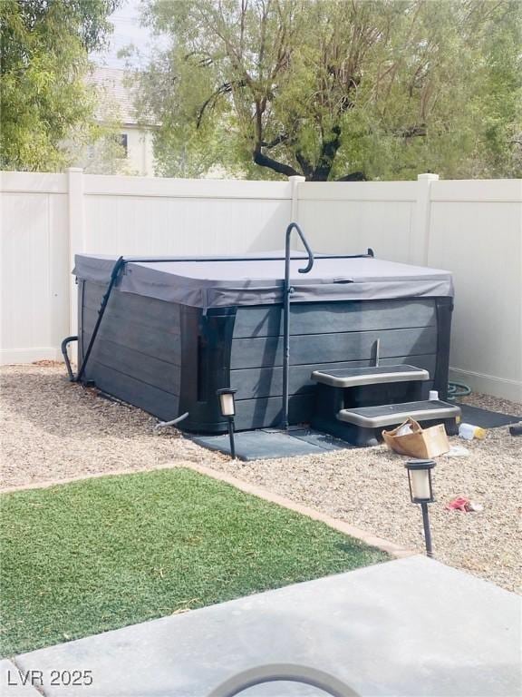 view of yard featuring fence and a hot tub