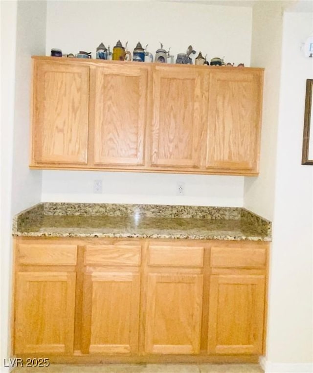 kitchen with light stone countertops and light brown cabinets