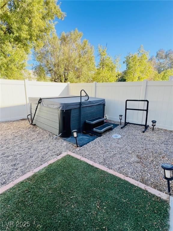 view of yard featuring a hot tub and a fenced backyard