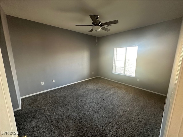 spare room featuring baseboards, a ceiling fan, and dark colored carpet