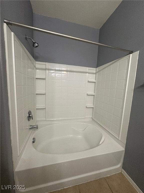 bathroom with tile patterned flooring, bathtub / shower combination, and baseboards