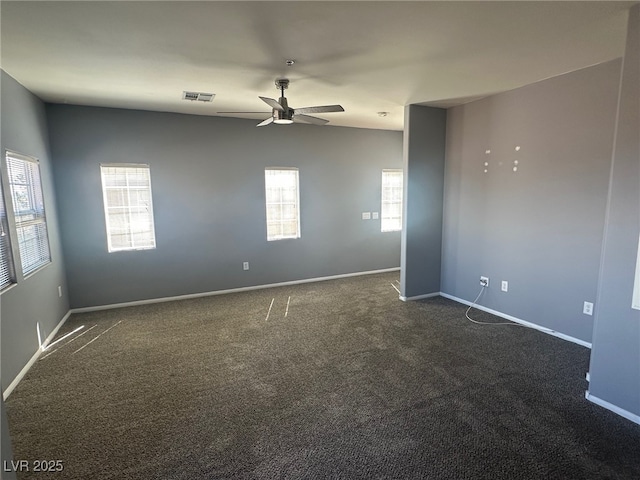 unfurnished room featuring dark colored carpet, visible vents, baseboards, and a ceiling fan