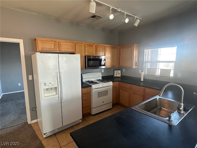 kitchen with visible vents, a sink, dark countertops, white appliances, and light tile patterned floors