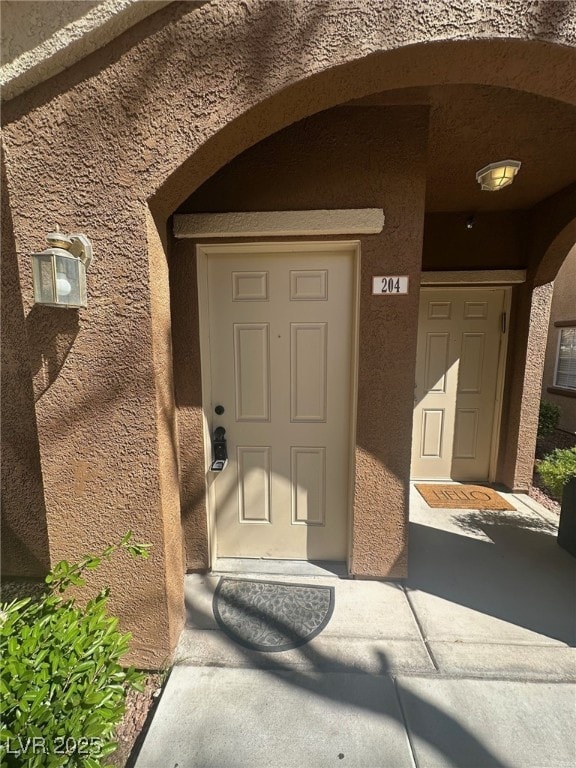 entrance to property featuring stucco siding