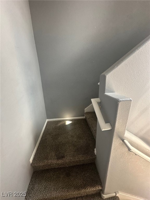 stairs featuring baseboards and carpet