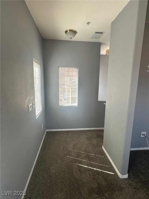 empty room with carpet flooring, baseboards, and visible vents