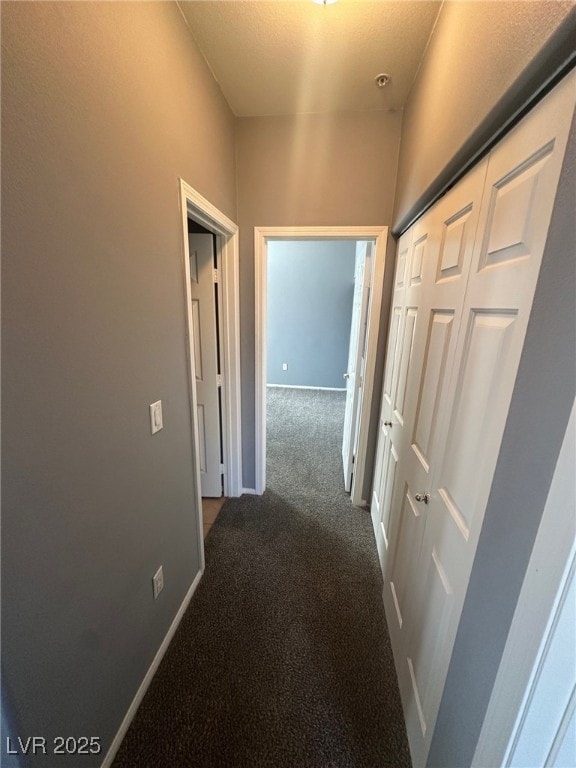 hallway with carpet flooring and baseboards