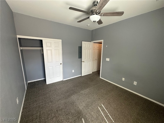 unfurnished bedroom featuring dark colored carpet, a closet, baseboards, and ceiling fan