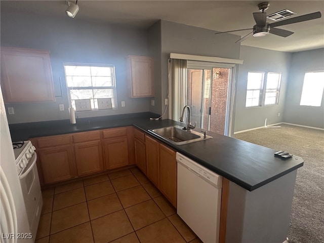 kitchen featuring white appliances, a healthy amount of sunlight, a peninsula, ceiling fan, and a sink