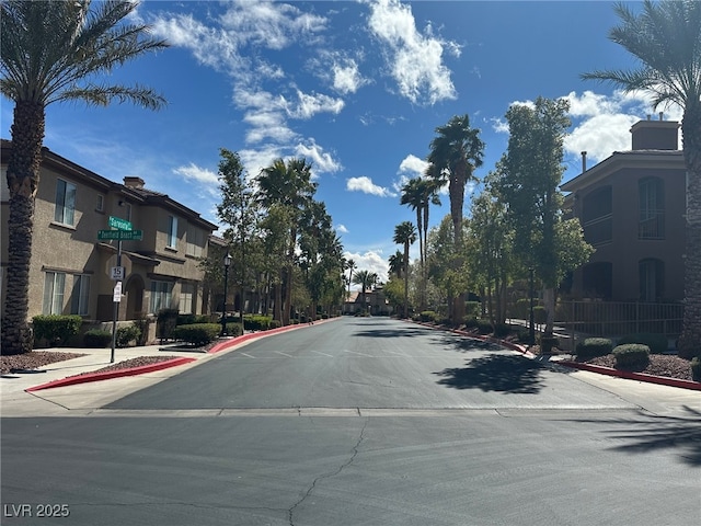 view of street with curbs, traffic signs, and sidewalks