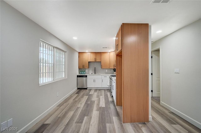 kitchen with backsplash, baseboards, light countertops, light wood-style flooring, and stainless steel appliances