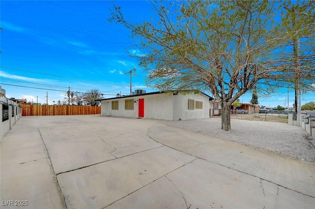 exterior space featuring stucco siding and fence