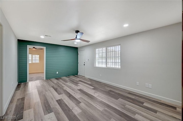 spare room featuring wood finished floors, a ceiling fan, baseboards, visible vents, and recessed lighting