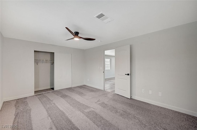 unfurnished bedroom with visible vents, a closet, carpet floors, baseboards, and ceiling fan