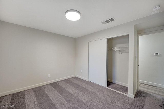 unfurnished bedroom featuring a closet, visible vents, carpet, and baseboards