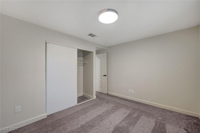 unfurnished bedroom featuring visible vents, carpet floors, baseboards, and a closet