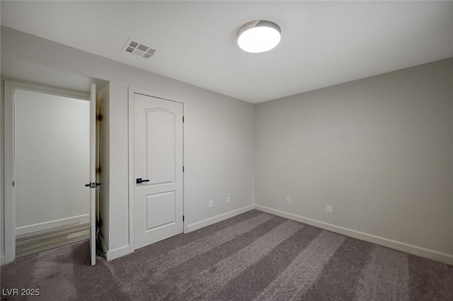 unfurnished bedroom featuring visible vents, baseboards, and carpet