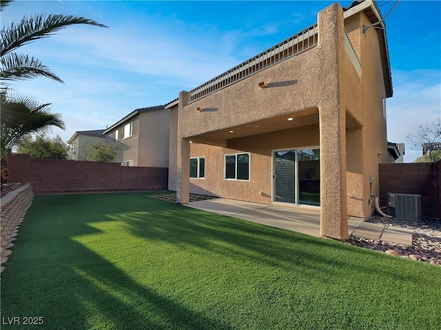 rear view of house featuring a fenced backyard, central AC, and stucco siding