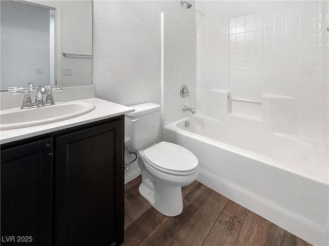 bathroom with washtub / shower combination, toilet, vanity, and wood finished floors