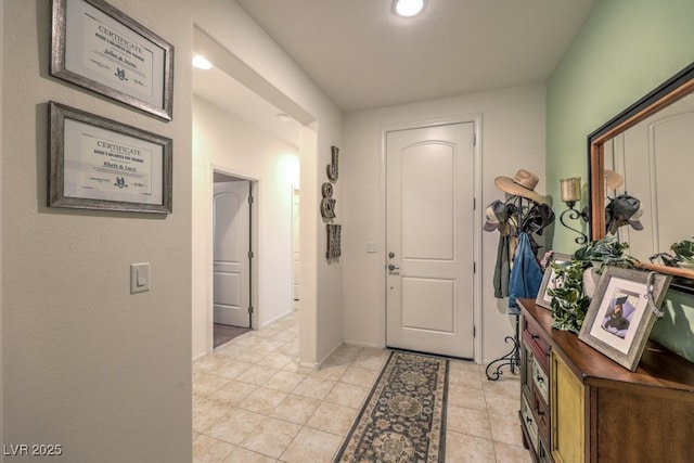 foyer with light tile patterned floors and baseboards