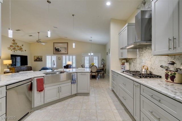 kitchen with light tile patterned floors, stainless steel appliances, open floor plan, wall chimney range hood, and tasteful backsplash