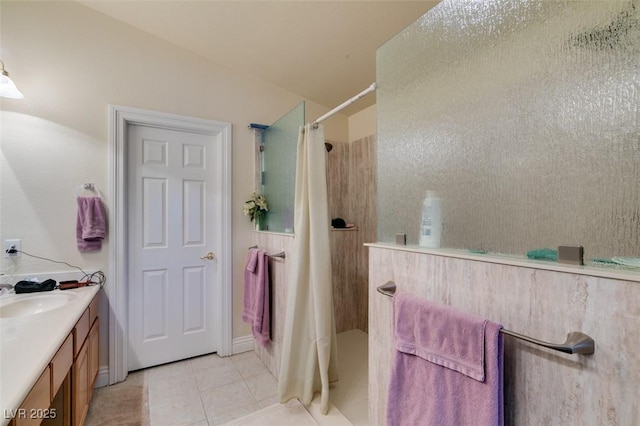 full bath with walk in shower, vanity, and tile patterned flooring