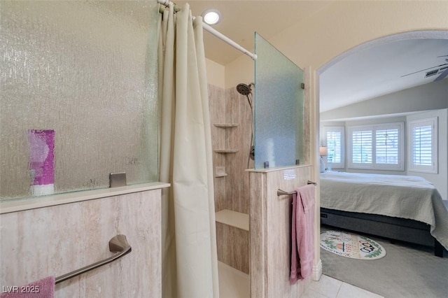 ensuite bathroom featuring a tile shower, visible vents, ensuite bathroom, and lofted ceiling