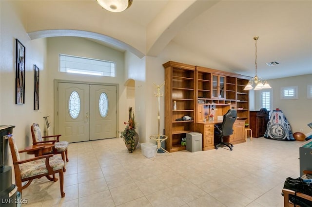 foyer entrance with visible vents, high vaulted ceiling, arched walkways, light tile patterned flooring, and a chandelier