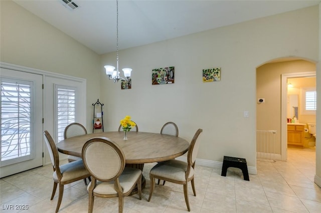 dining room with visible vents, a notable chandelier, arched walkways, light tile patterned floors, and baseboards