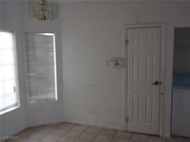 unfurnished room featuring an inviting chandelier and a wealth of natural light