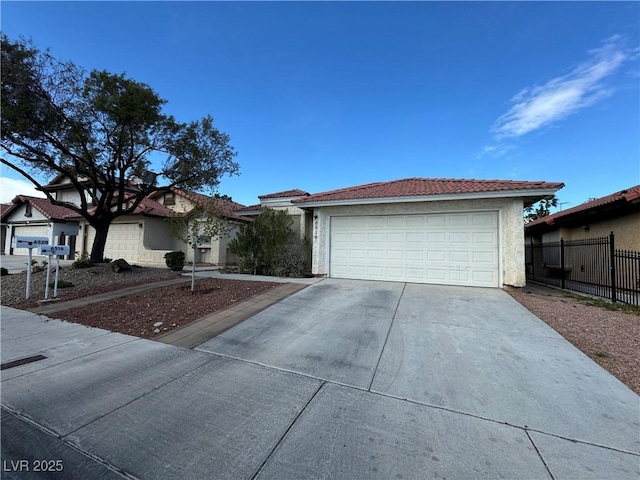 view of front of home with fence, stucco siding, concrete driveway, a garage, and a tile roof